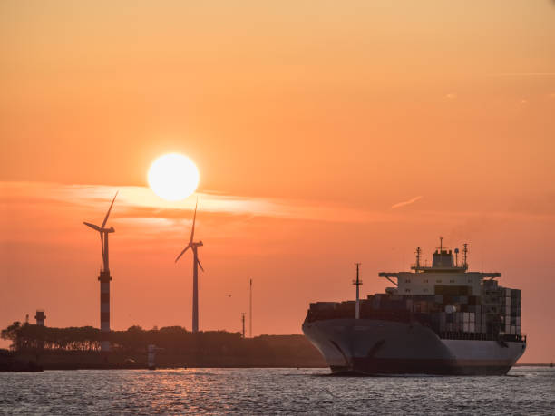 Container ship arrives to port of Rotterdam during sunset stock photo