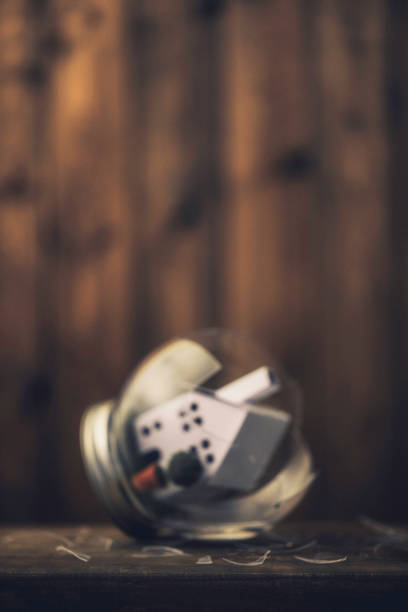 red dice fall out of a leather dice cup lying on a metal shelf