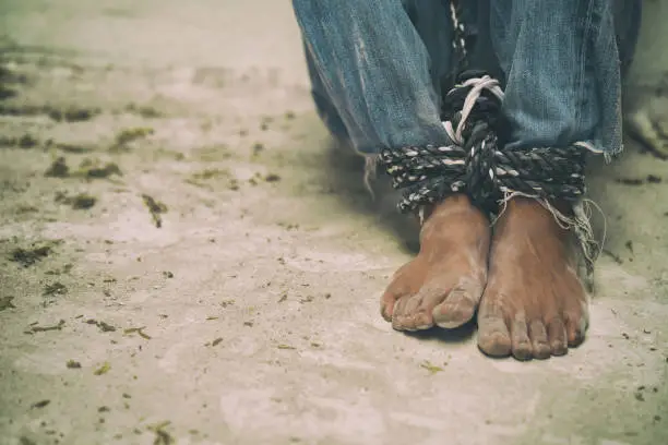 Photo of hopeless man feet tied together with rope