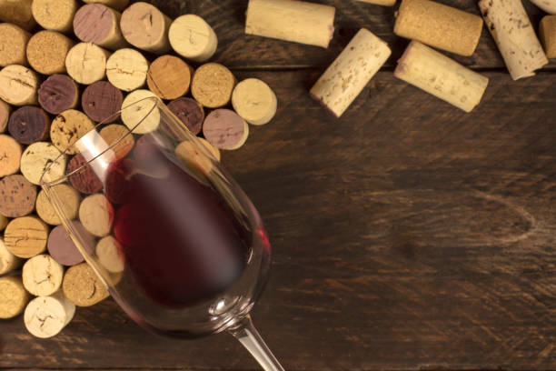 istock Glass of red wine and corks on dark background 641077460