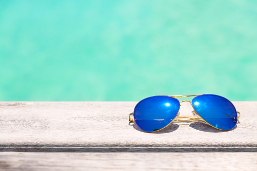 Blue Sunglasses on a wooden deck, summer holiday concept