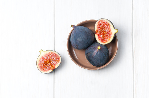 Top flat view: fresh figs on white wooden background