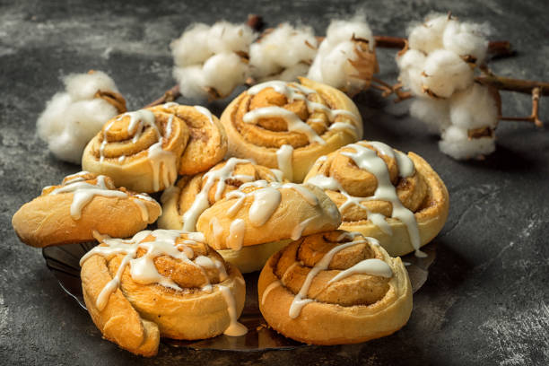 istock fresh delicious cinnamon rolls on the plate on a dark black cement background with cotton boxes behind 641082402