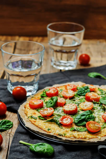 istock Cauliflower pizza crust with tomato and spinach 641084600