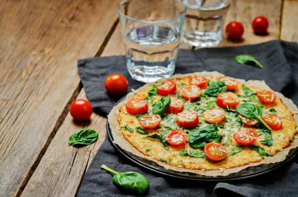 istock Cauliflower pizza crust with tomato and spinach 641084606