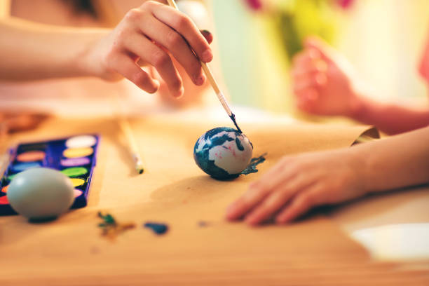 istock Close up of small kid painting Easter eggs 641085846