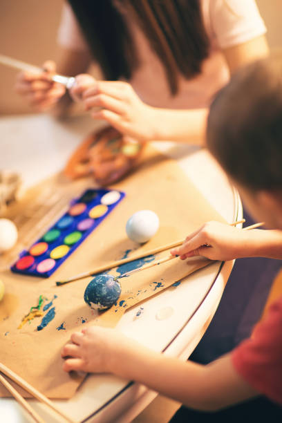 istock Close up of small kid painting Easter eggs 641086012