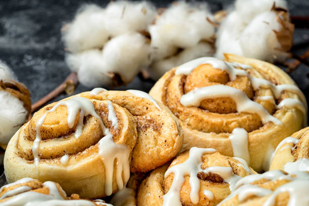 istock close up cinnamon rolls on the plate, on a dark cement table, cotton boxes behind. 641092894