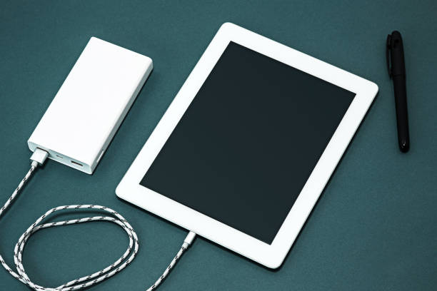 Power bank, pen and laptop on gray desk