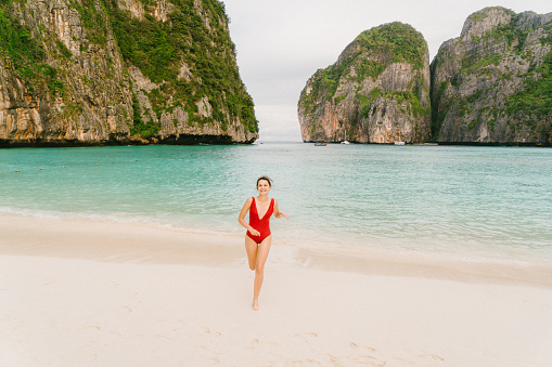 Young Caucasian woman walking on the beach in Maya Bay in Thailand