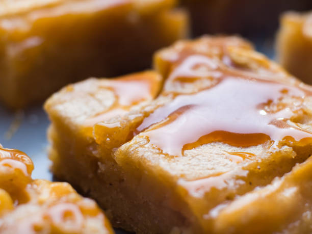 Closeup of apple blonde broiwnies with caramel Home made apple cinnamon blondies with salted caramel. Sweet food dessert macro detail blondy stock pictures, royalty-free photos & images