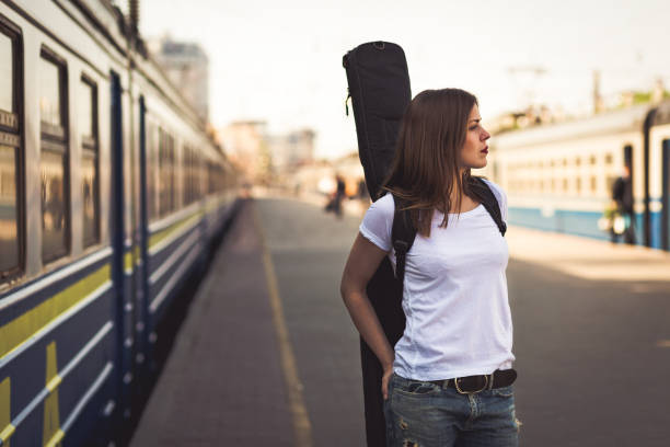istock Woman with guitar at the railway station 641122440