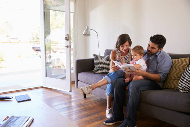 istock Parents Reading With Baby Daughter On Sofa At Home 641123244