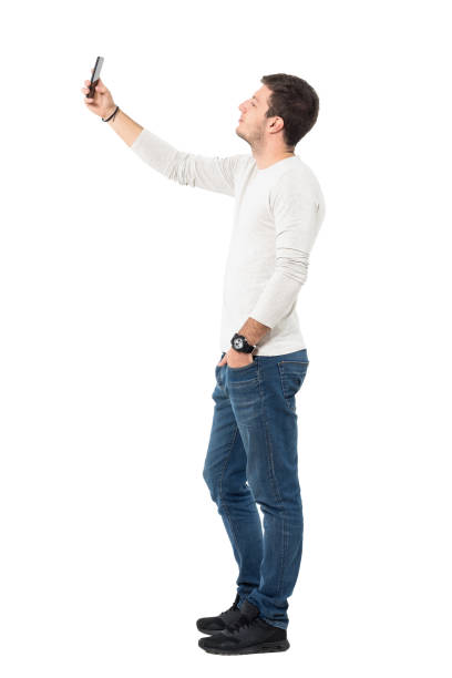 istock Side view of young man taking selfie with mobile phone 641124392