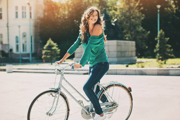 schöne junge frau mit dem fahrrad an einem sonnigen tag - bike park stock-fotos und bilder