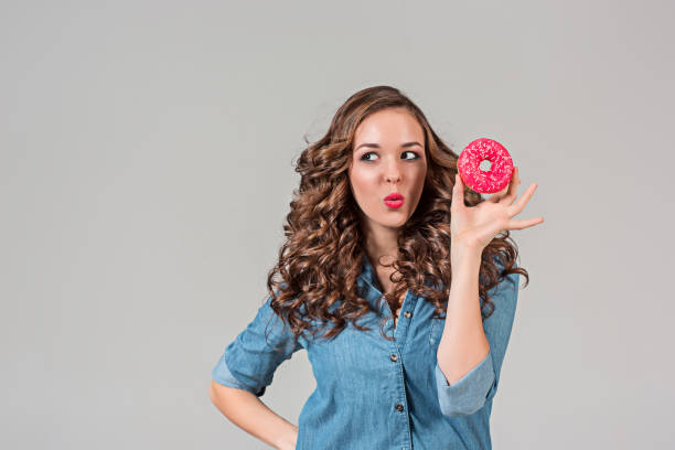 istock The smiling girl on gray studio background with round cake 641131594