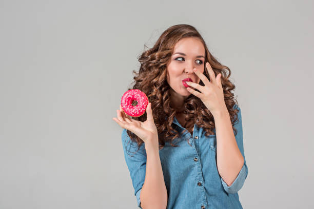 istock The smiling girl on gray studio background with round cake 641131702