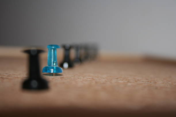 istock One blue pin among black ones in the cork-board 641137134