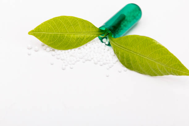 Open capsule with green leaf growing out from it stock photo