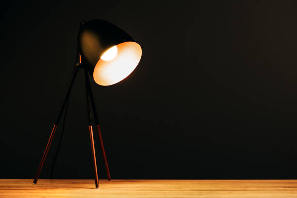 istock Desk lamp on table in dark office with copy space 641148940
