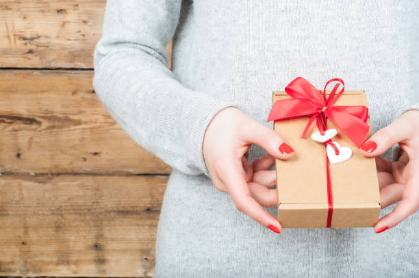 istock Hands holding gift in kraft box on a wooden background 641150550