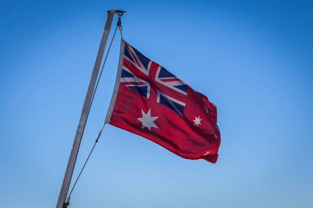 istock Australian Red Ensign flag on pole against blue sky background. 641159548