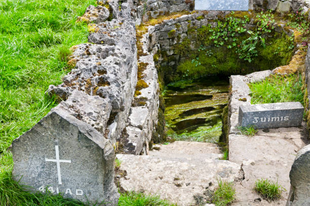 Well of Saint Patrick at Ballintubber Abbey in County Mayo, Ireland. The Well of Saint Patrick at Ballintubber Abbey in Ballintubber, County Mayo, Ireland. He baptised the people in year 441AD at the well. Beside the well there is a stone on which the supposed imprint of the Saint’s knee is on it. norman style stock pictures, royalty-free photos & images