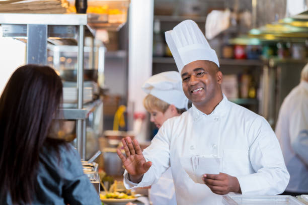 istock Confident male chef talks with female server 641159870