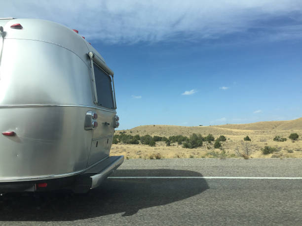 Travel Trailer on the Open Road Mobilestock image of a road trip travel trailer. Taken on a cross country road trip in 2016. motor home photos stock pictures, royalty-free photos & images