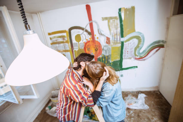 Two people, heterosexual couple, DIY, painting, kissing.