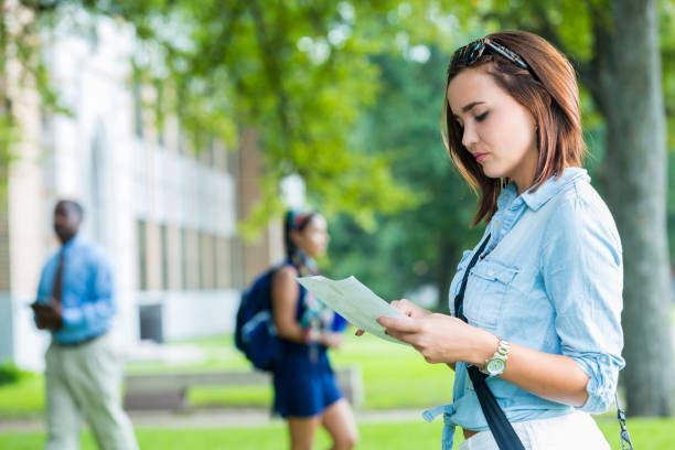 istock Serious female college student looks at class schedule 641168490