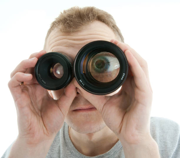 man looking through a lens - magnifying glass lens holding europe imagens e fotografias de stock