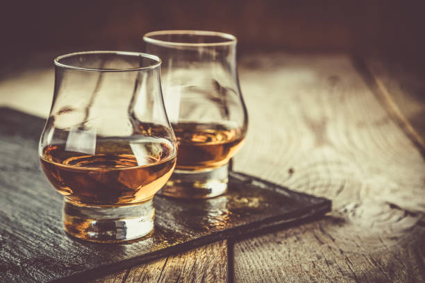Whiskey with ice in glasses Whiskey with ice in glasses, rustic wood background, copy space liquor store counter photos stock pictures, royalty-free photos & images