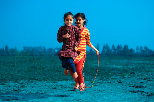 Two little girls playing in playground outside early in the morning.