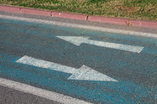 Three arrow sign painted on asphalt road in the city of Caracas