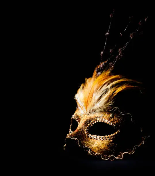 Golden venetian mask over black background
