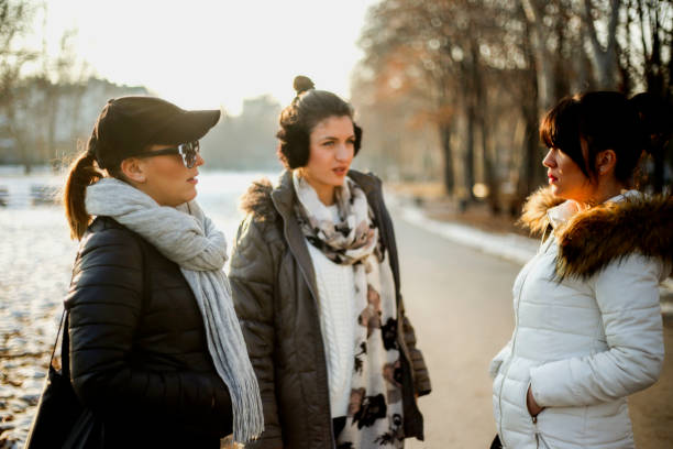 istock Three girls talking in park 641183592