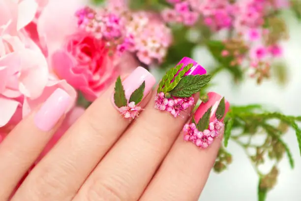 Pink manicure with a design of flowers.