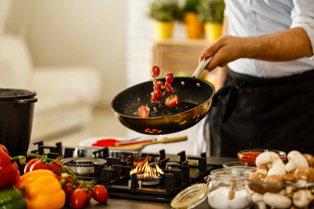 chef che tossa verdure dalla padella - padella pentola foto e immagini stock