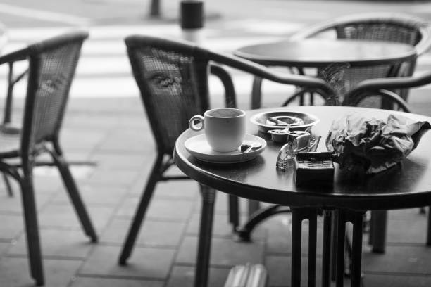 cafe table with coffee, cigarette, drink and glasses