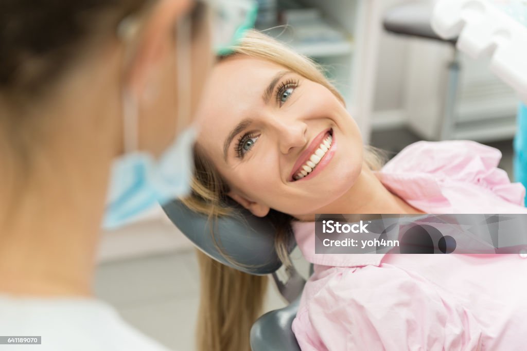 Schöne Patienten lächelnd an Arzt - Lizenzfrei Zahnarzt Stock-Foto