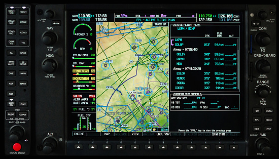 Airplane glass cockpit display with terrain and engine gauges in small private airplane
