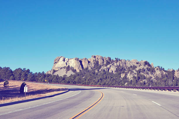 Retro color toned road to Mount Rushmore National Memorial, USA. Retro color toned road to Mount Rushmore National Memorial, South Dakota, United States. theodore roosevelt us president stock pictures, royalty-free photos & images