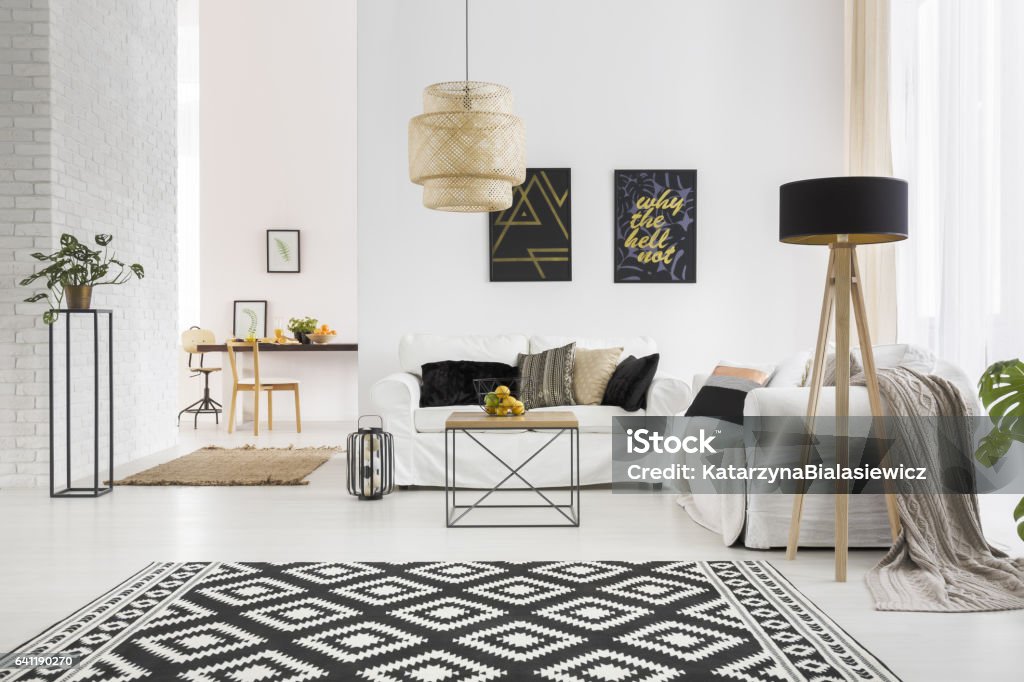 Apartment with white brick wall Apartment with white brick wall, sofa, table and pattern rug Living Room Stock Photo