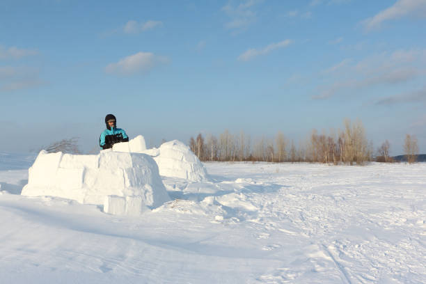 istock Man building an igloo of snow blocks 641191738