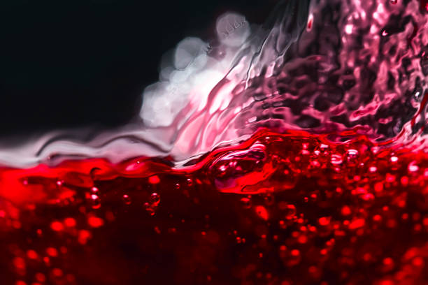 istock Abstract splashes of red wine on a black background 641193738