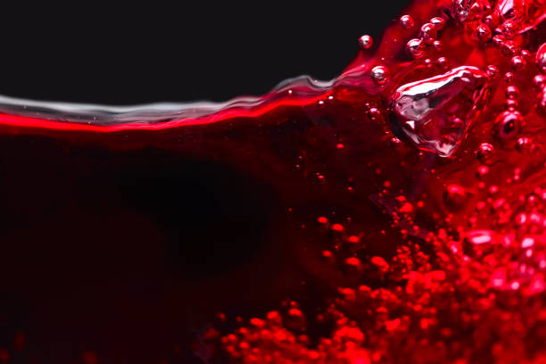 istock Abstract splashes of red wine on a black background 641194842
