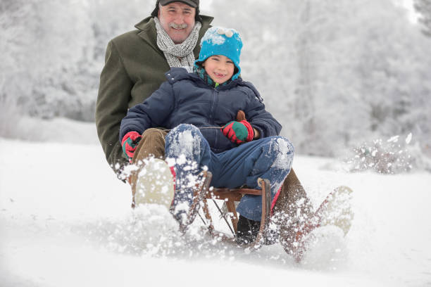 istock Grandfather with grandson sledding 641195440