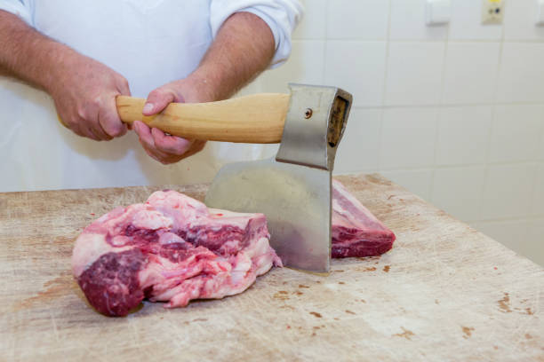 istock Butcher with a chisel handles raw pork 641195962