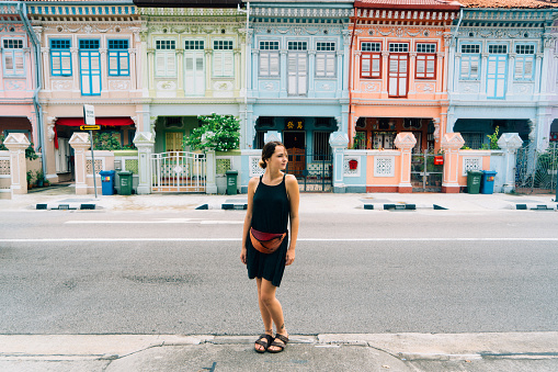 Young Caucasian woman near Colorful buildings in Katong district in Singapore